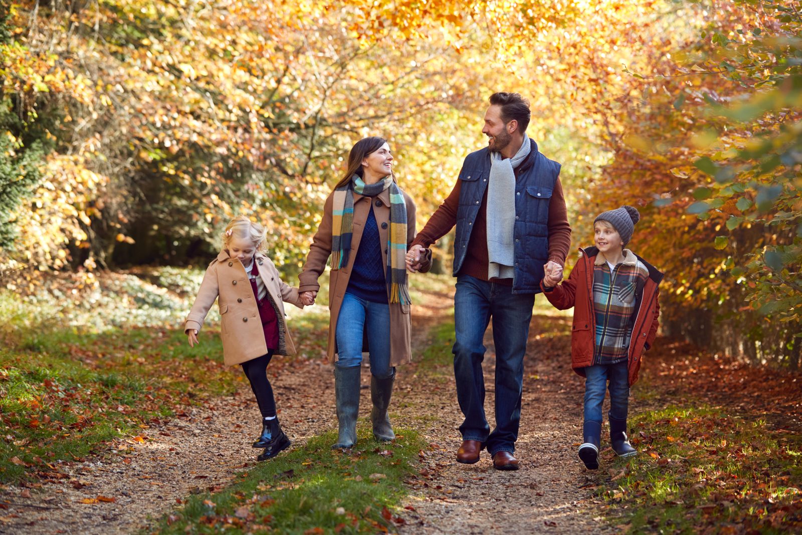 Familie beim Herbstspaziergang auf einem Waldweg