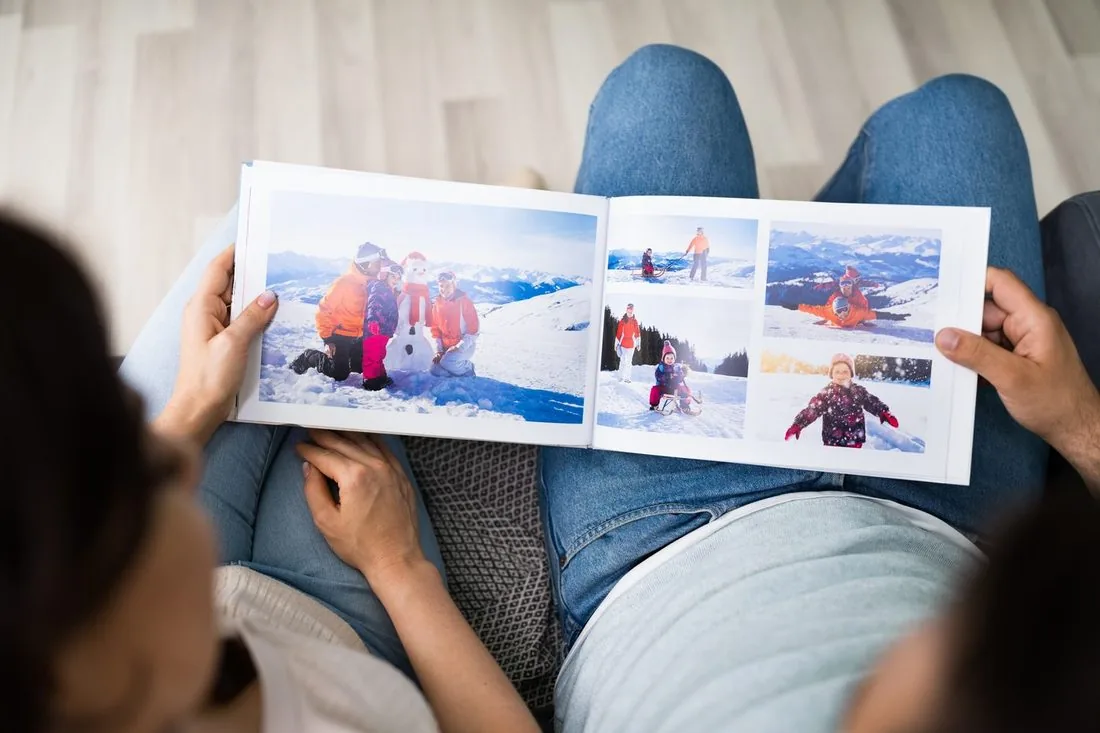 Paar betrachtet gemeinsam ein Fotobuch mit detailreichen Bildern aus digitalisierten Mittelformat-Negativen